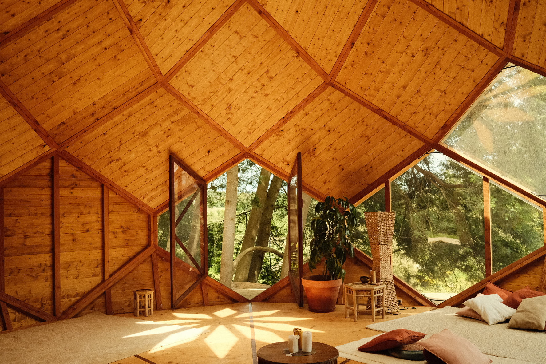 Sunlight illuminating the warm geometric timber interior of a Zome